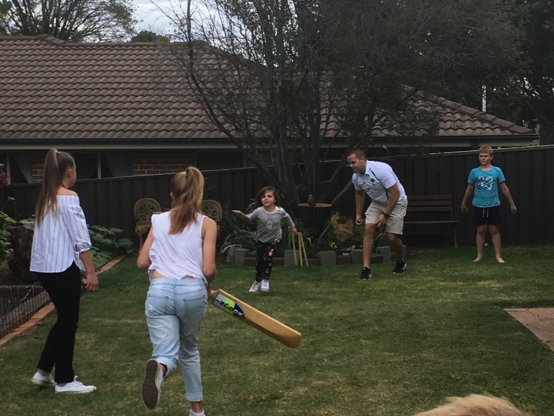 Dan Hunt playing cricket with kids during a wellbeing visit
